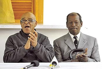 Marvin Patrick (l.) and Willie Vereen, two of the surviving Wilmington 10, applaud Gov. Perdue's decision to pardon them during a news conference.