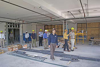Joshua Littlejohn (center), Green Opportunities Project Manager, shows visitors the extensive HVAC system, part of the Reid Center renovation project.   Photos: Urban News