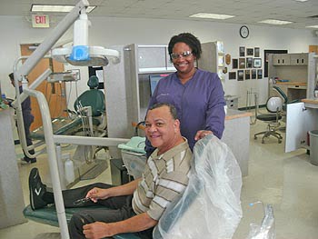 100 Men and Women Minority Scholarship recipient Tiffany McDowell (standing) and Samuel Abdul-Allah are all smiles after Tiffany, a dental hygienist student, completed Samuel’s dental cleaning. Photo: Urban News