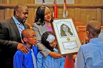 Mayor Bellamy shows nephew Keith Whitmire (right) her official mayoral portrait that will hang in Asheville City Hall. (L-R) Husband Lamont Bellamy, children Seth and Imani. Photo: Renato Rotolo/Urban News