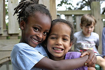 Evergreen kindergarteners, Sebla Miracle and Marisol Brown, enjoy the outdoors on Evergreen’s playground.