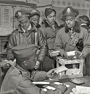 March 1945. “Escape kits” (cyanide) being distributed to fighter pilots at air base in Ramitelli, Italy. Theodore G. Lumpkin Jr., seated, with (L-R): Joseph L. “Joe” Chineworth, Memphis, Class 44-E; Robert C. Robinson, Asheville, Class 44-G; Driskell B. Ponder, Chicago, 43-I; Robert W. Williams, Ottumwa, Iowa, 44-E. Tuskegee Airmen series. Silver gelatin print by Toni Frissell.