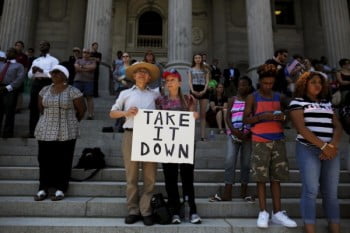 Kuniharu (L) and Barbara Kubodera stand during moment of silence at a rally outside the State House to get the Confederate flag removed from the grounds in Columbia, South Carolina, June 23, 2015.  South Carolina lawmakers plan to introduce a resolution on Tuesday to begin a debate on removing the Confederate flag from the State House grounds following the killings of nine African-American churchgoers allegedly by a white gunman. REUTERS/Brian Snyder      TPX IMAGES OF THE DAY