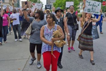 Najiyyah Avery (center) mother of Jai “Jerry” Williams carries the teddy bear that belonged to Jerry when he was a child.  Photo: Micah Simpson/Urban News