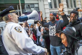 An officer from the NYPD addresses protesters during a march through the Manhattan borough of New York City
