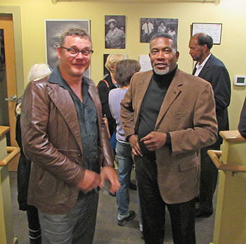 UNCA Professor Darin Water (right) greets an attendee of the Isaiah Rice Photo Exhibit. Photo: Urban News