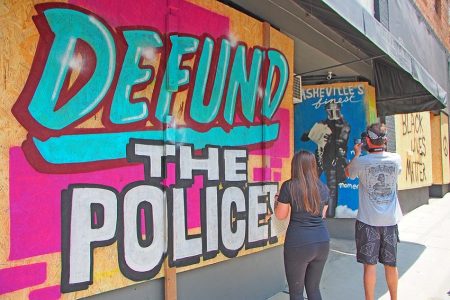 defund police artwork on boarded up window