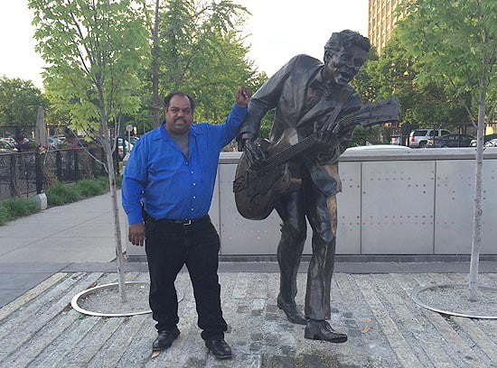 Blues musician Daryl Davis next to statue of Chuck Berry in St Louis