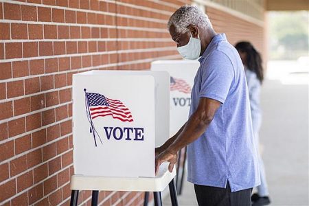 man voting wearing mask outdoors