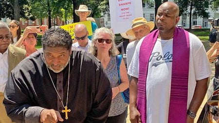 Rev. William Barber II speaks during the protest while Donte Sharpe looks on.
