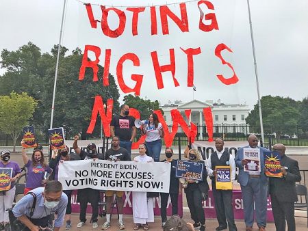 Activists stand in support of the Freedom to Vote Act and John Lewis Voting Rights Advancement Act.