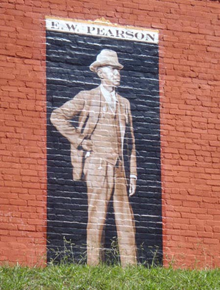 A mural of E.W. Pearson looks across the grassy field between the Burton Street Community Center and Bryant Street.