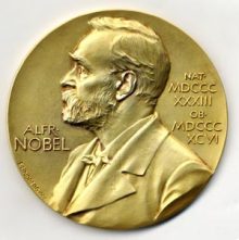 The gold Nobel Prize medal features a portrait of Alfred Nobel.