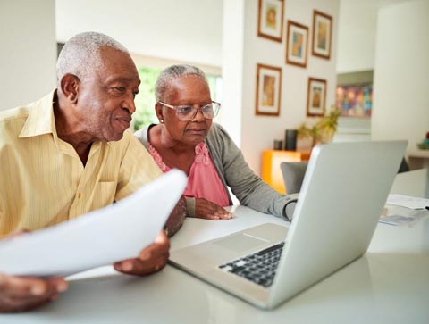 elderly couple using a laptop computer