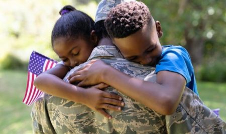 veteran hugs children