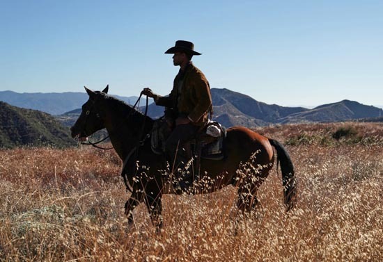 Black cowboy riding a horse