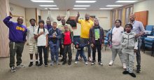 Students stand with the brothers of Psi Phi chapter of Omega Psi Phi after a STEM workshop.