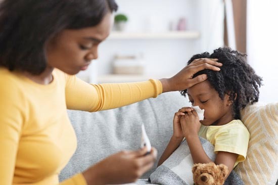 mother taking daughters temperature